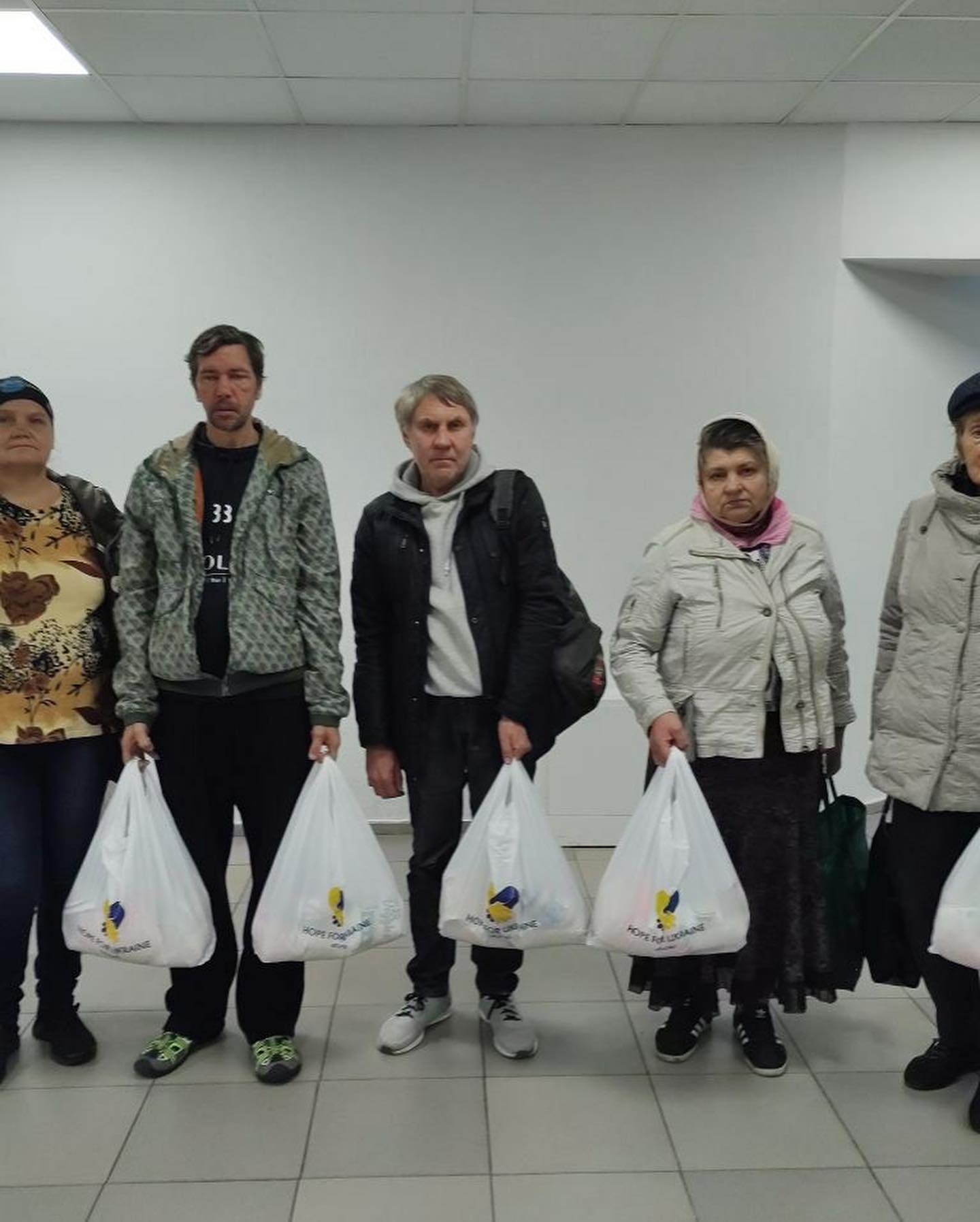 A group of people posing for a photo with shopping bags.