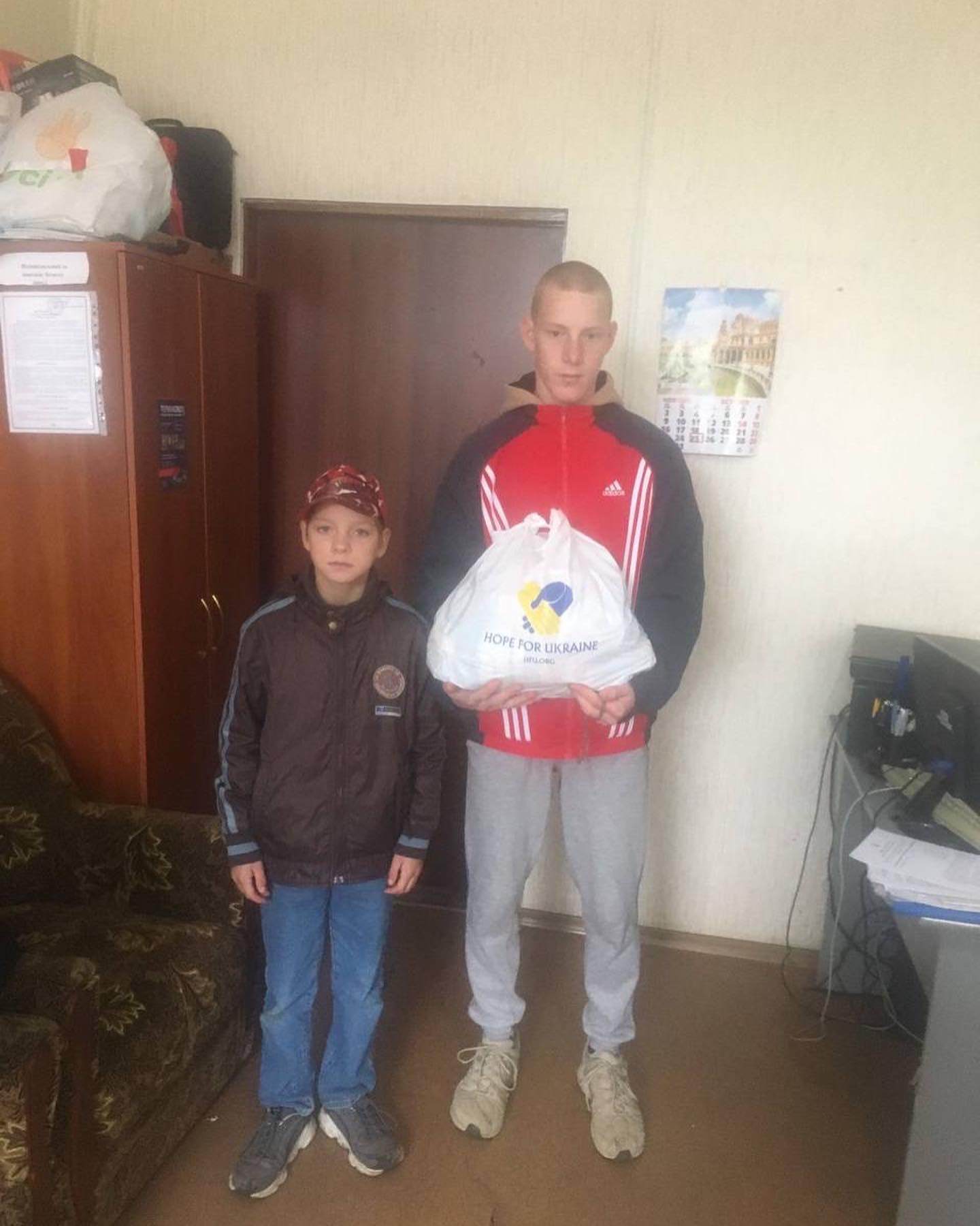 A man and a boy standing next to each other holding a bag.