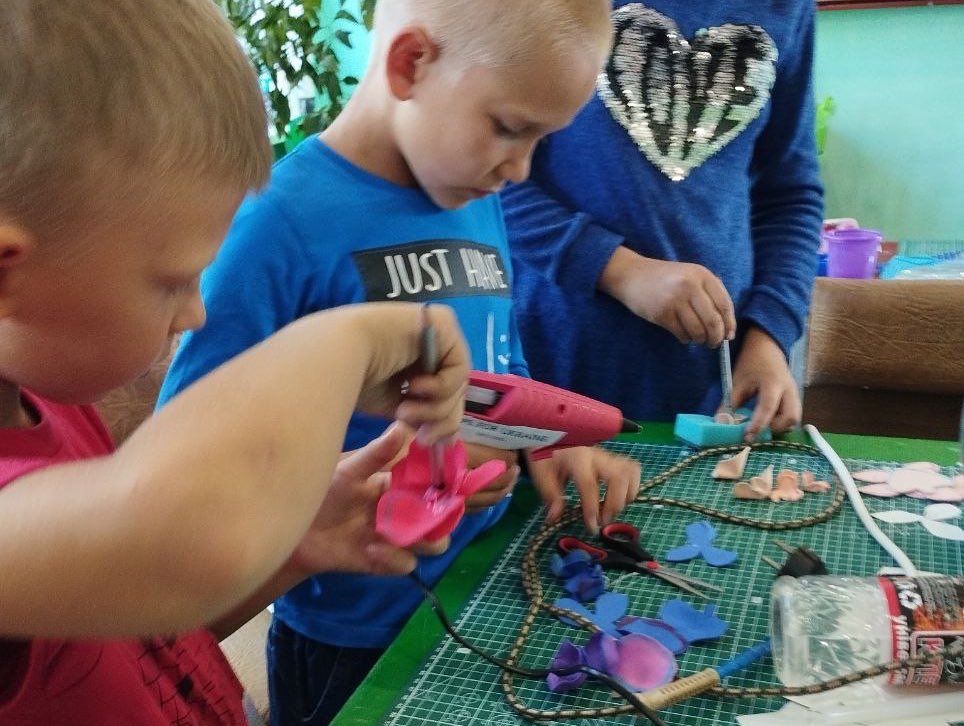 A group of children are making crafts at a table.