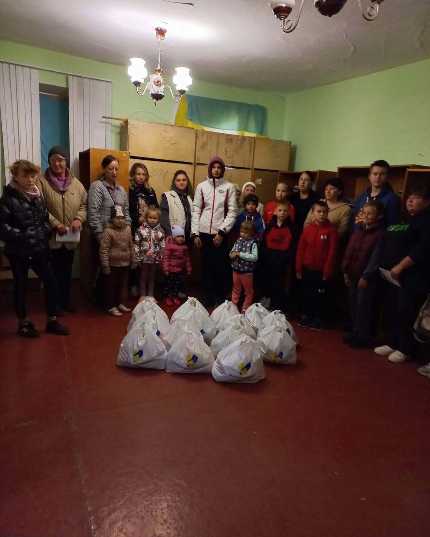 A group of people standing in a room with bags.