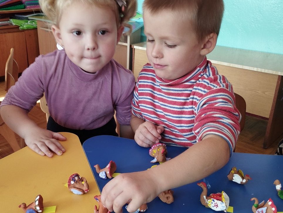 Two children playing with toys in a classroom.
