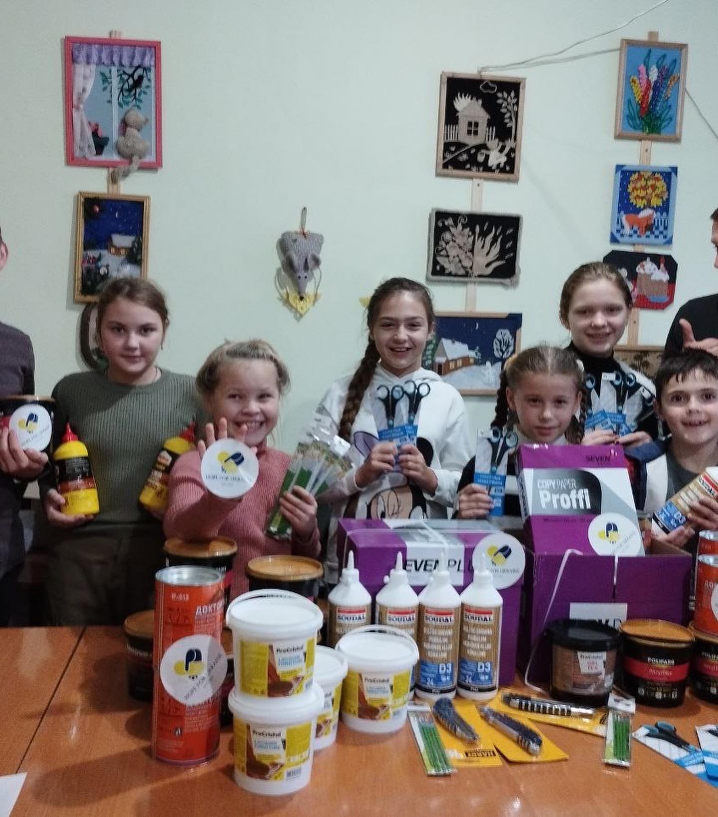 A group of children posing in front of a table full of products.