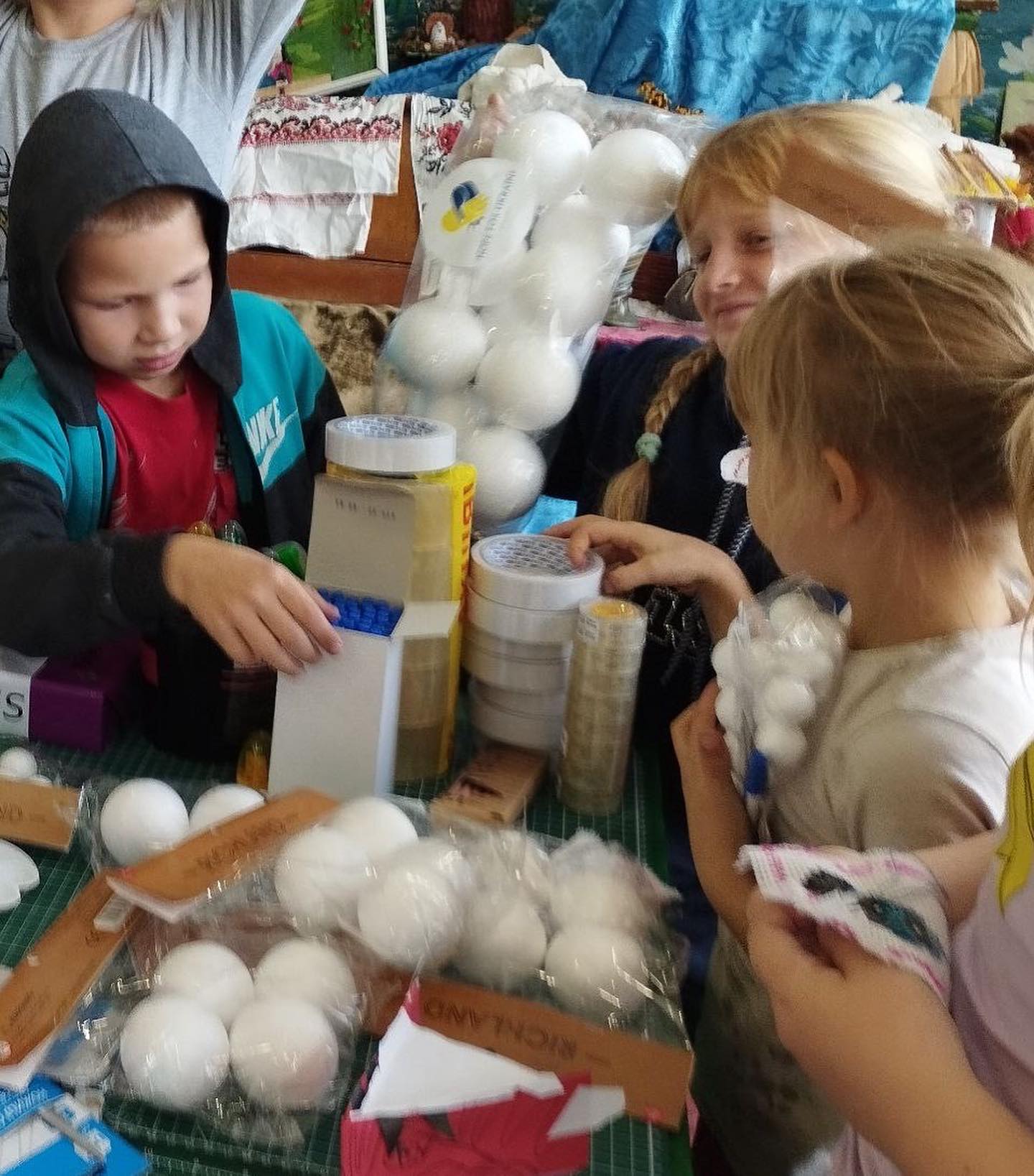 A group of children looking at a table full of white balls.