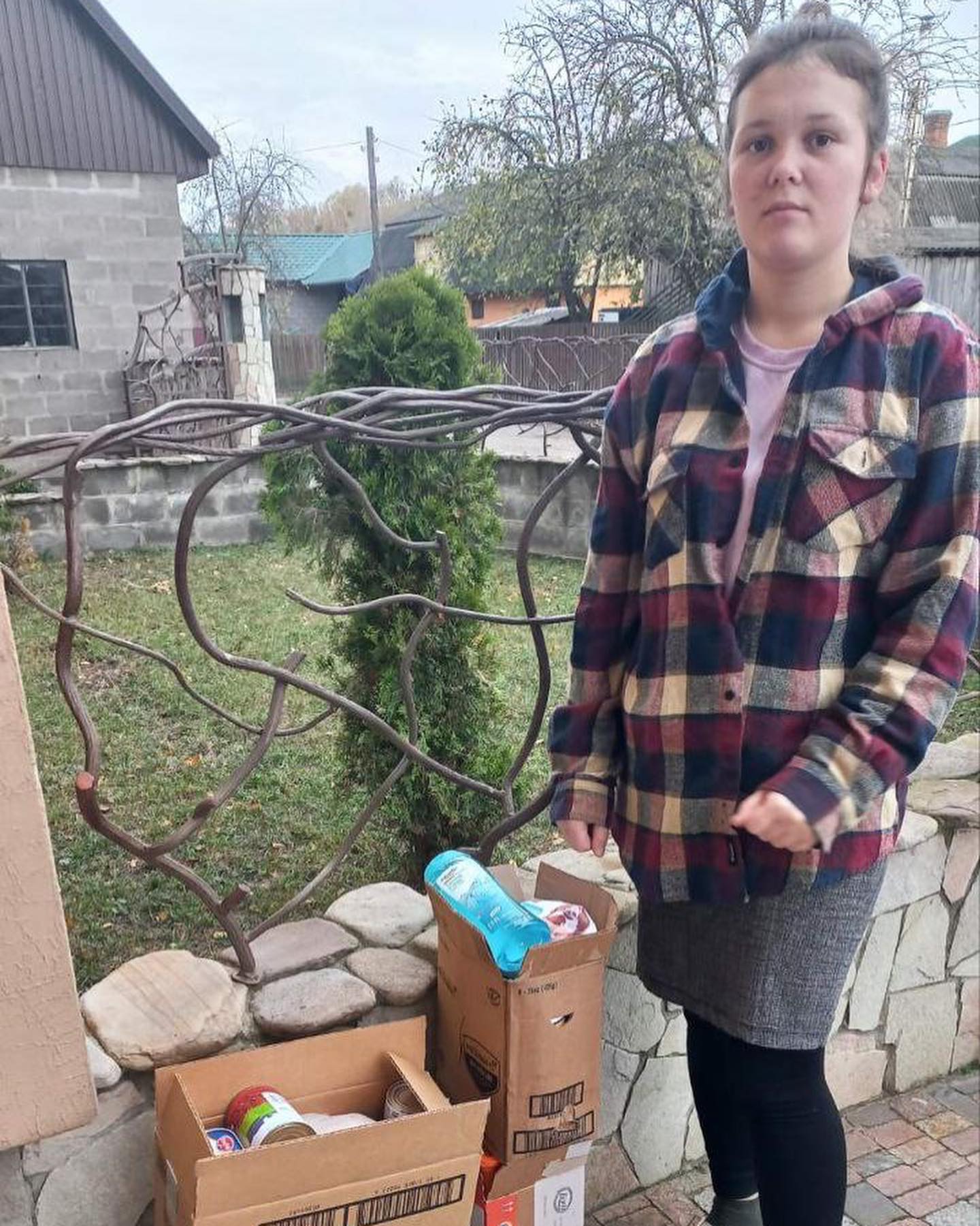 A girl standing next to boxes of food.
