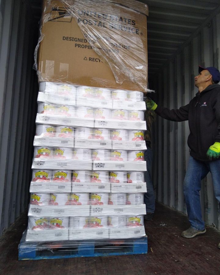 A man loading boxes into a shipping container.