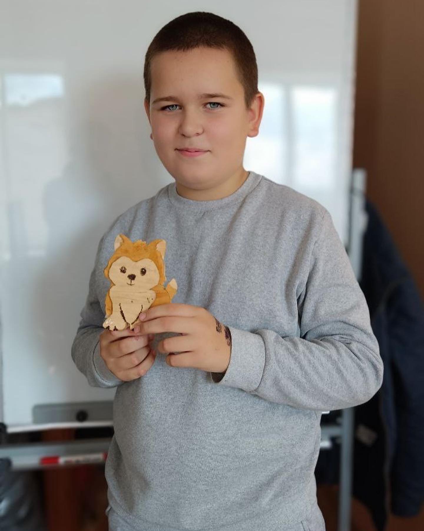 A young boy holding a wooden teddy bear.
