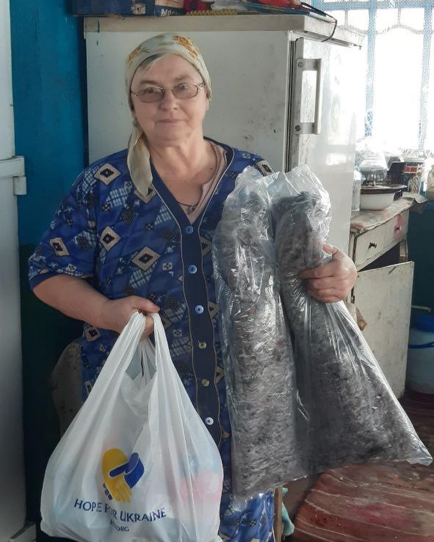 A woman is holding bags of fish in a kitchen.