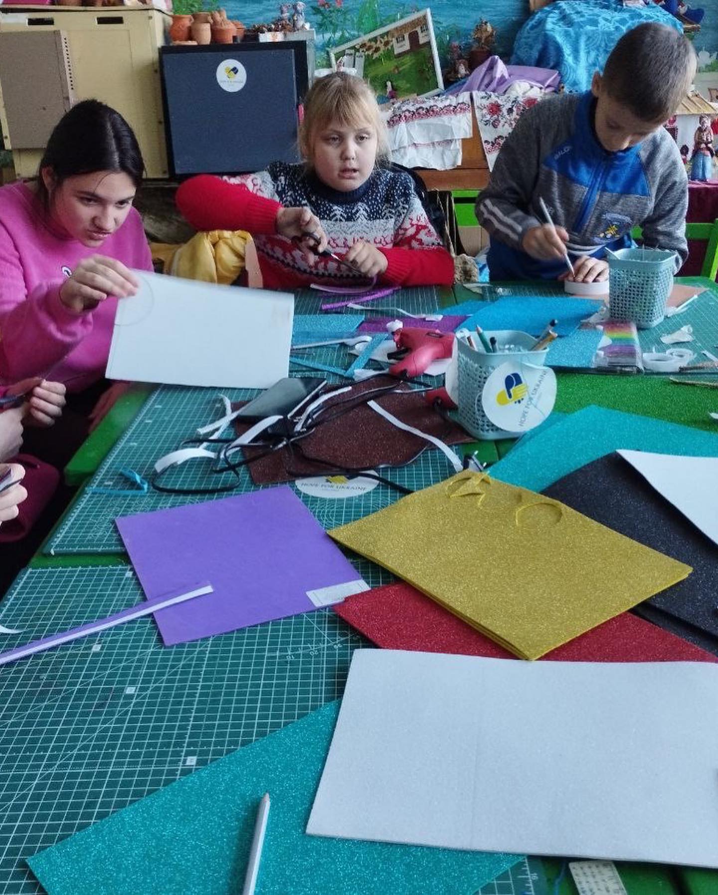A group of children are making crafts at a table.