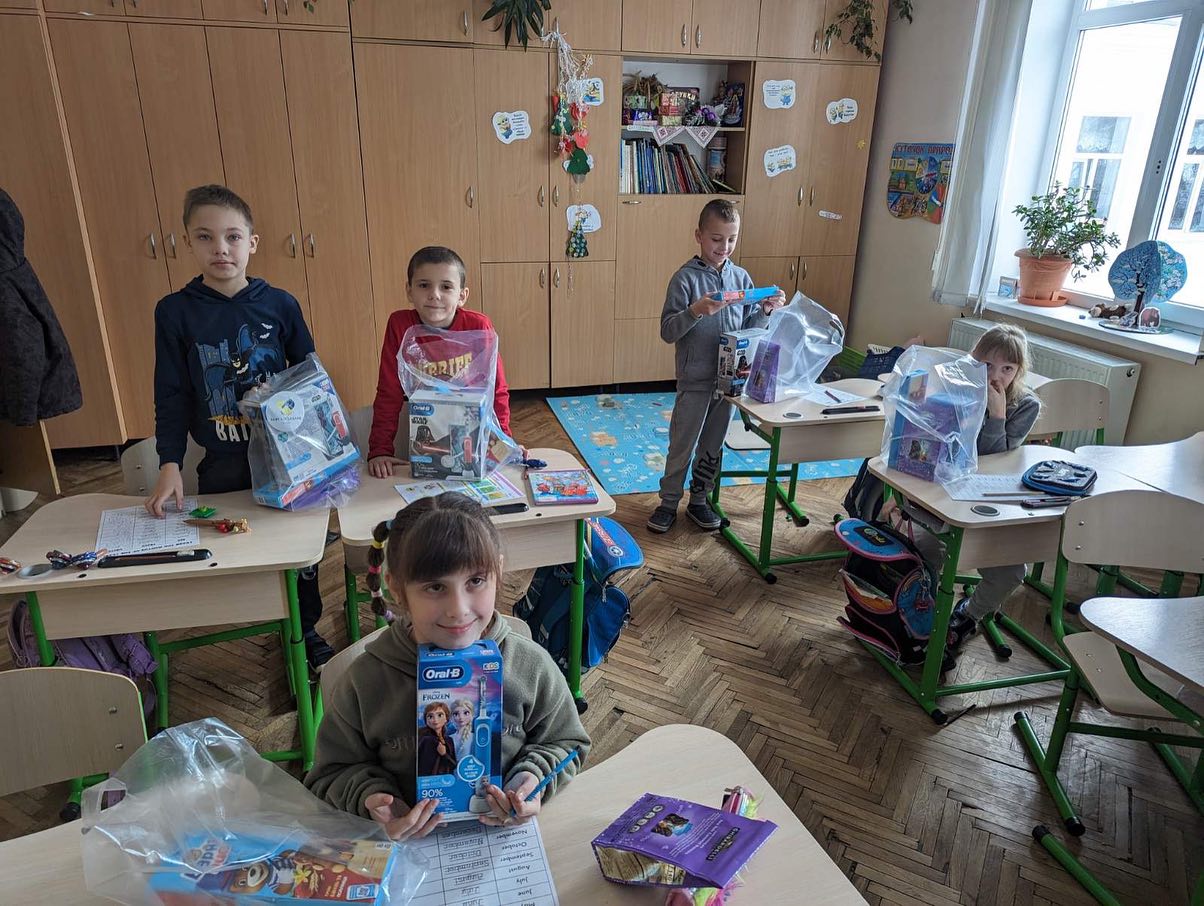 A group of children in a classroom with bags of toys.