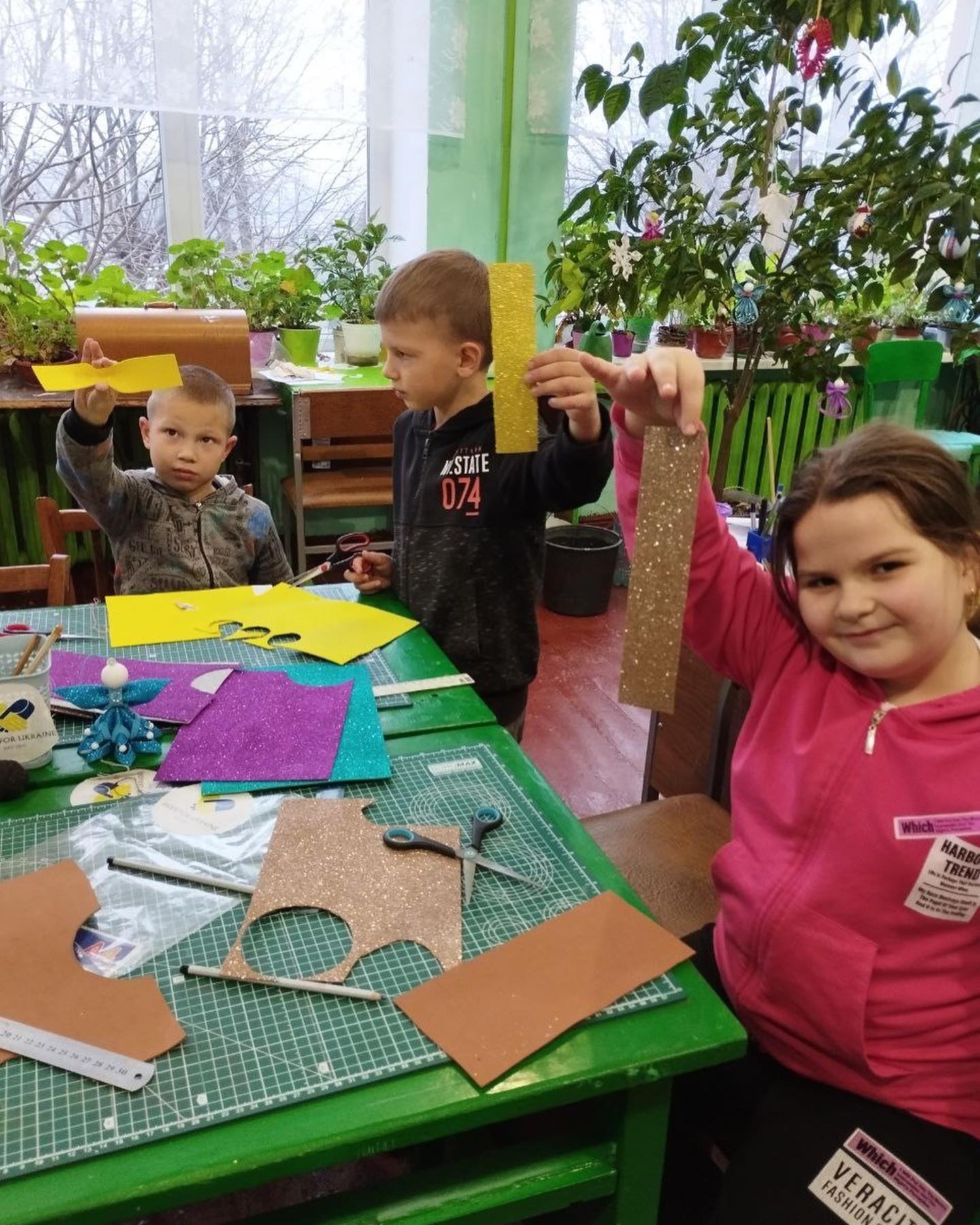 A group of children are making crafts in a classroom.
