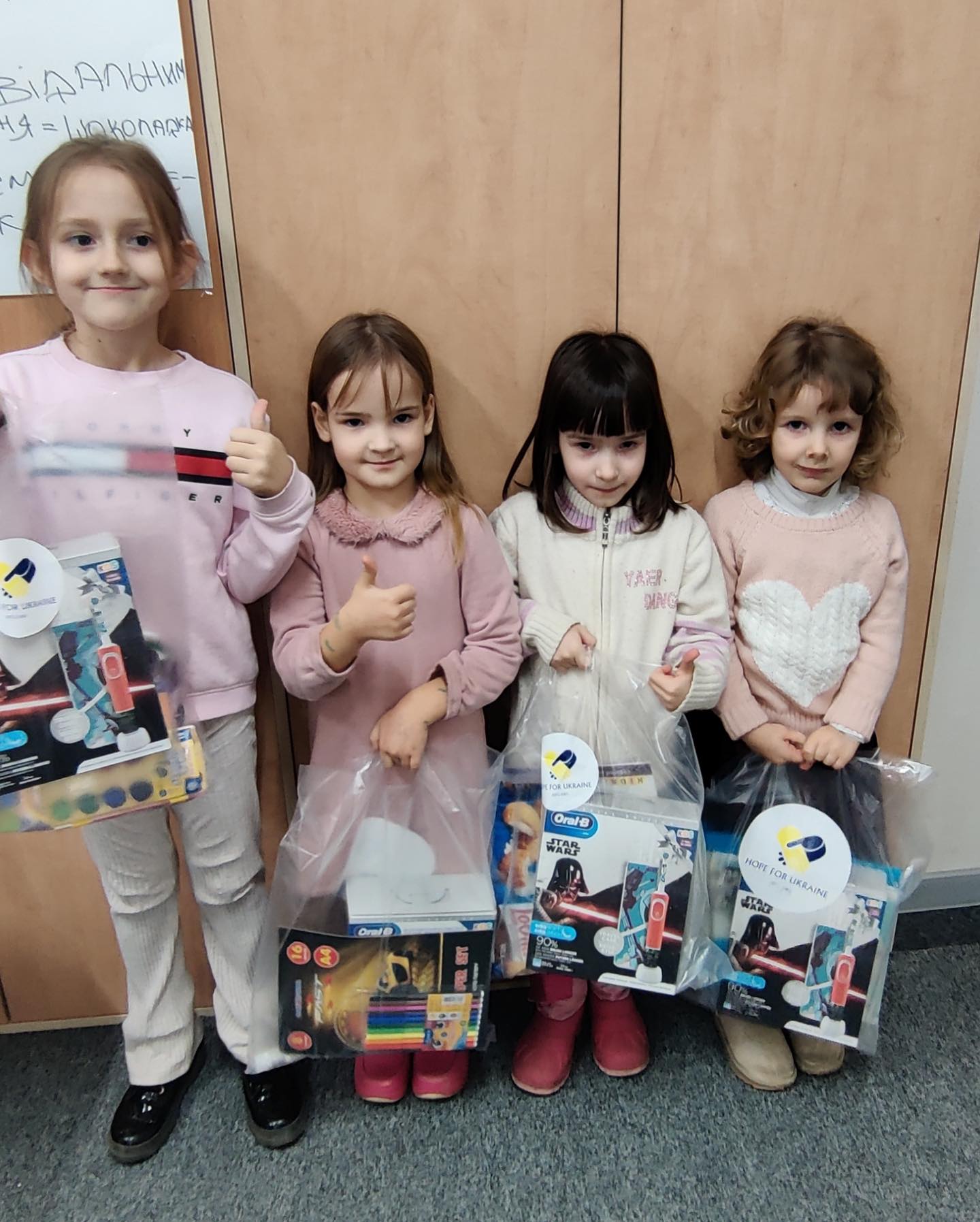 A group of young girls holding bags of toys.