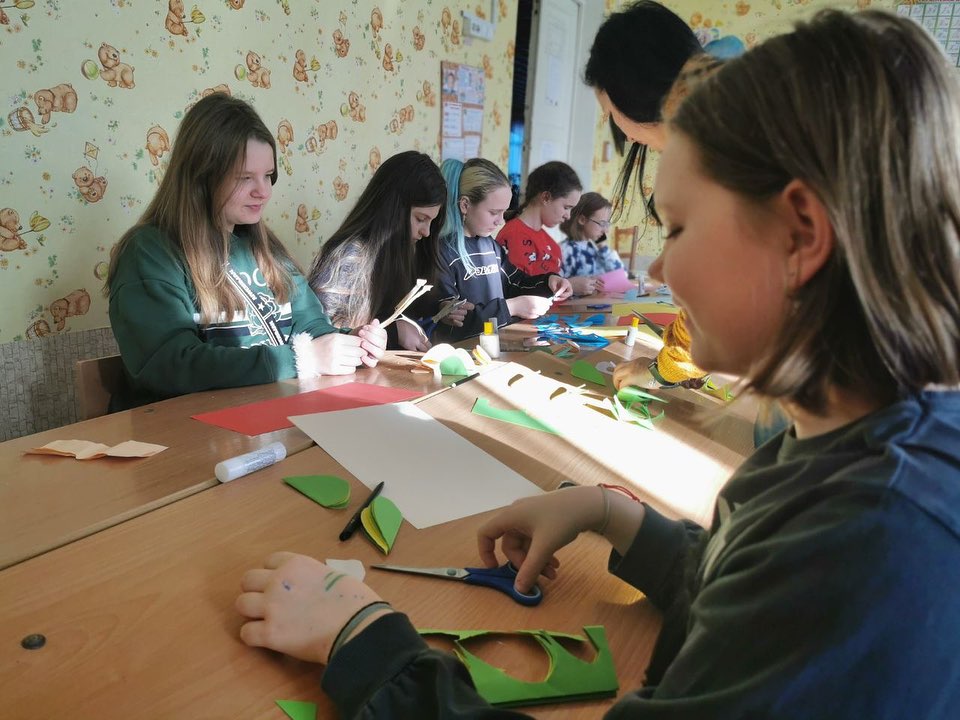 A group of girls are making crafts at a table.