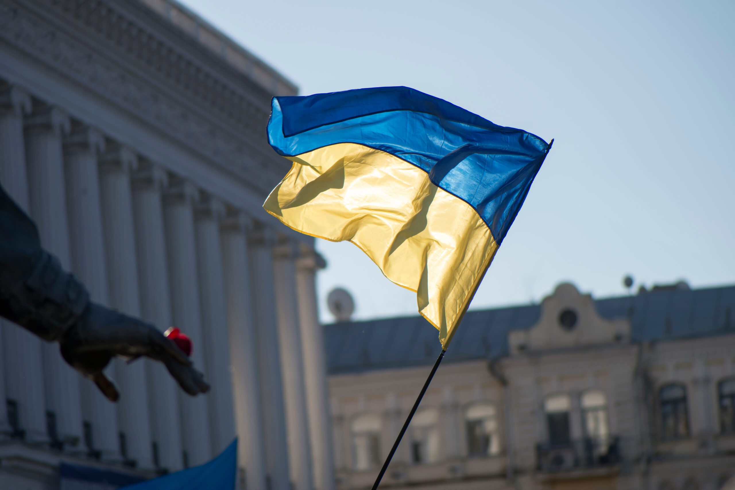 A Ukrainian flag is flying in front of a charity building.