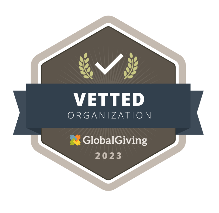 Badge displaying a checkmark with text: "Vetted Organization, GlobalGiving 2023" on a brown background with a ribbon and laurel design.