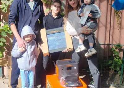 A family of five poses outdoors with Jackery solar power equipment, including a solar panel and generator, lighting more frontline homes and showcasing reliable, clean energy placed on the ground in front of them.