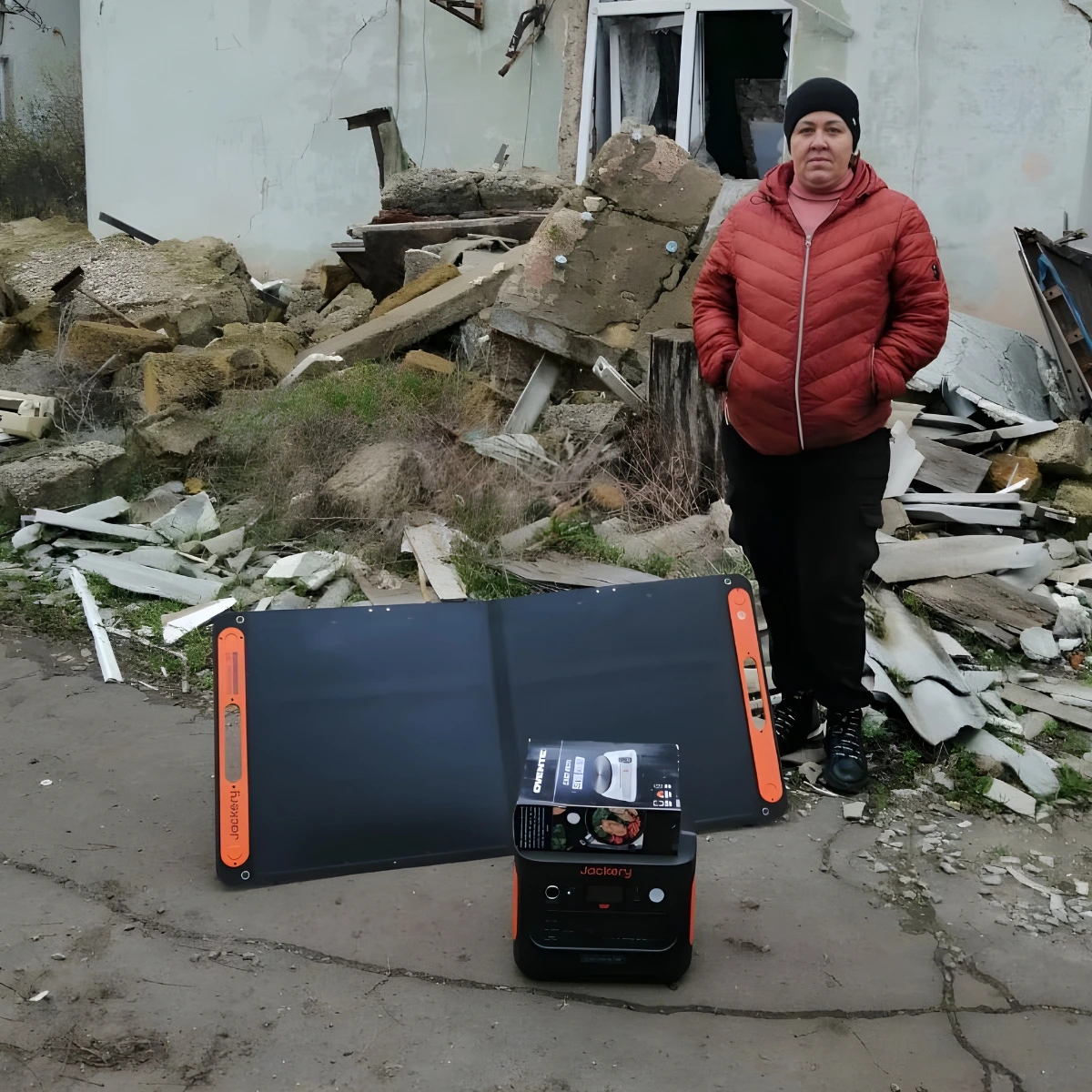 A woman standing in front of a pile of rubble.