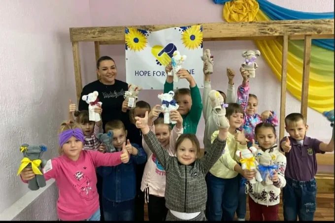 Children lined up holding gifts