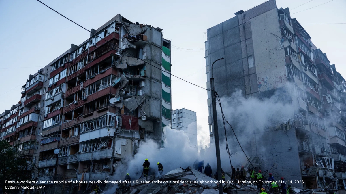 Rescue workers clear rubble from a heavily damaged residential building after a Russian strike in Kyiv, Ukraine, with smoke rising from the debris.