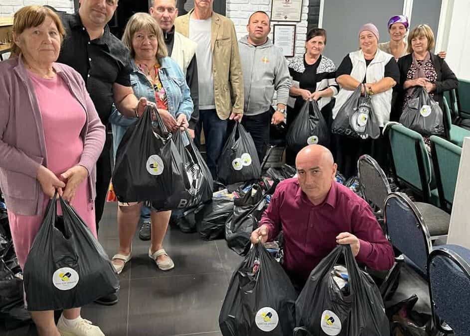 Group of people with aid packages in a community center.